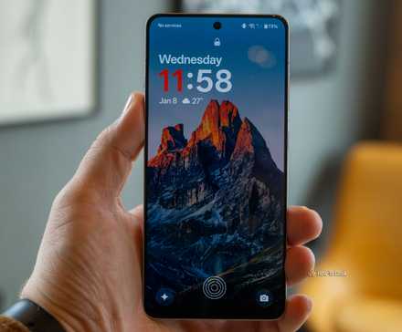 A person holding the OnePlus 13R on the lock screen.