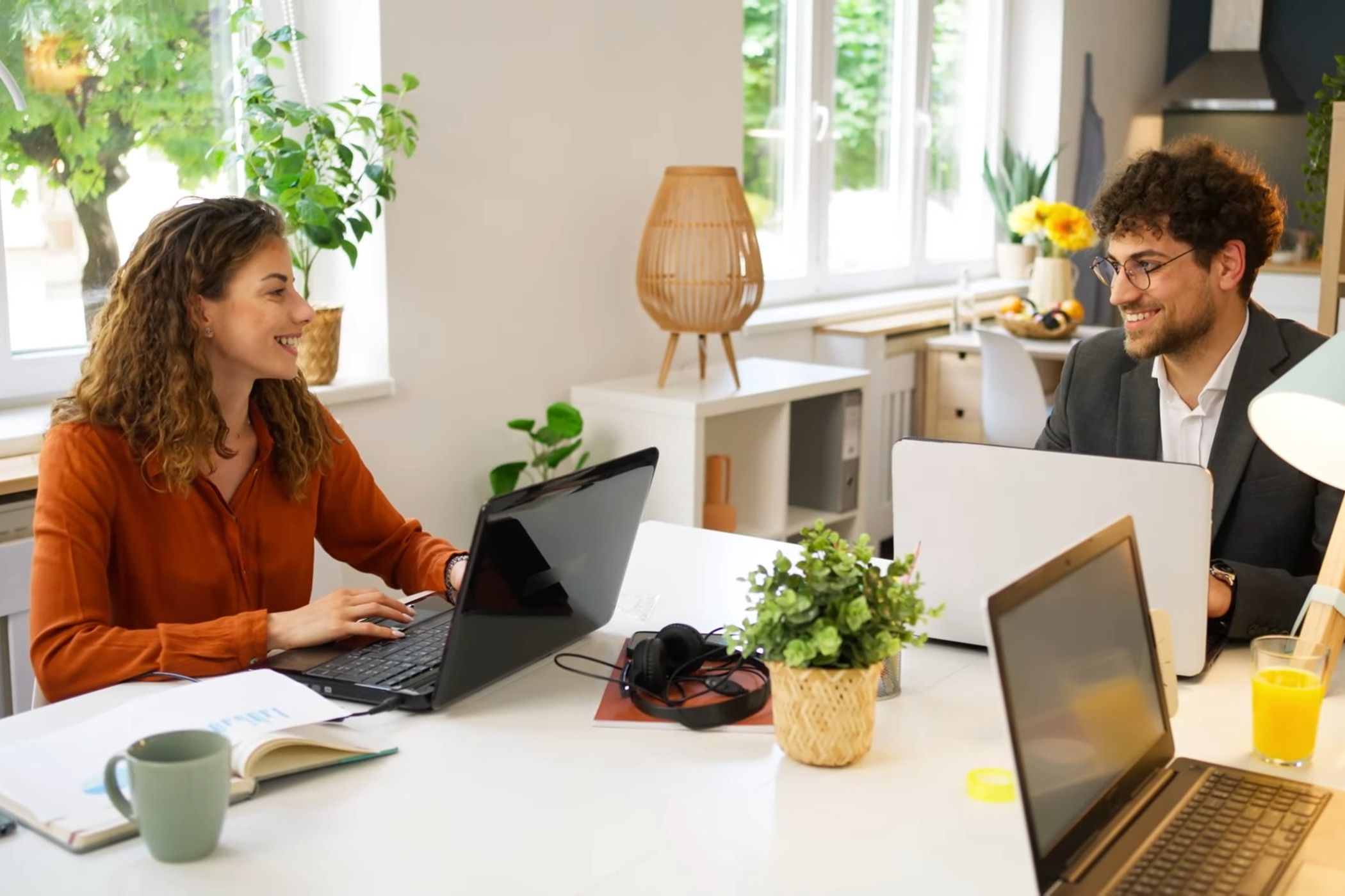Google Adaptive Audio being used in a shared workspace while two people smile at each other