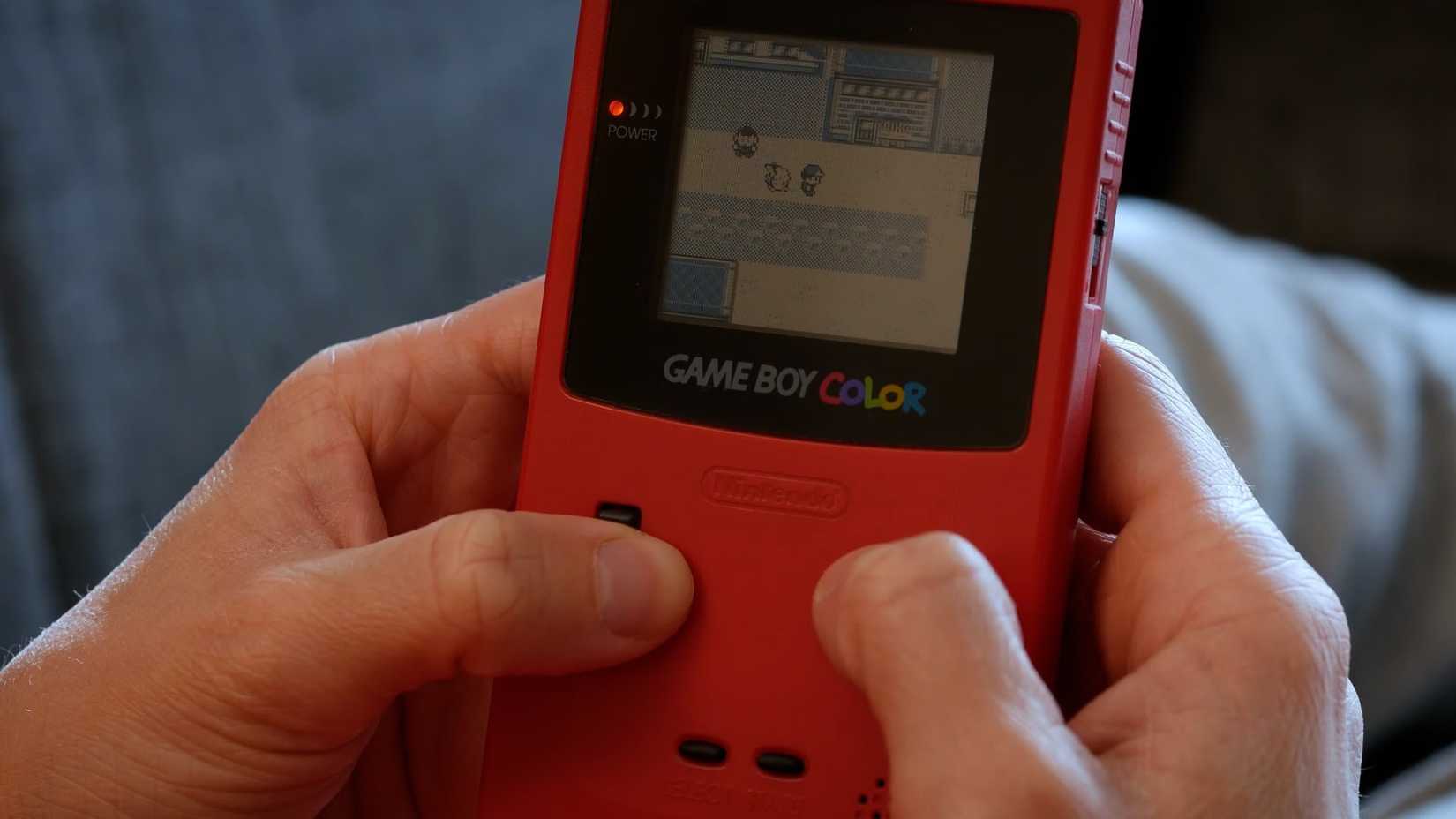 A person playing Pokemon yellow on a gameboy color.